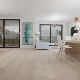 The living room which is connected to the kitchen. Wooden floor and white walls.